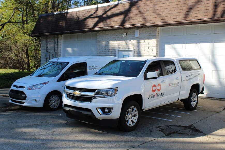 UnlimitComp branded service vehicles parked outside